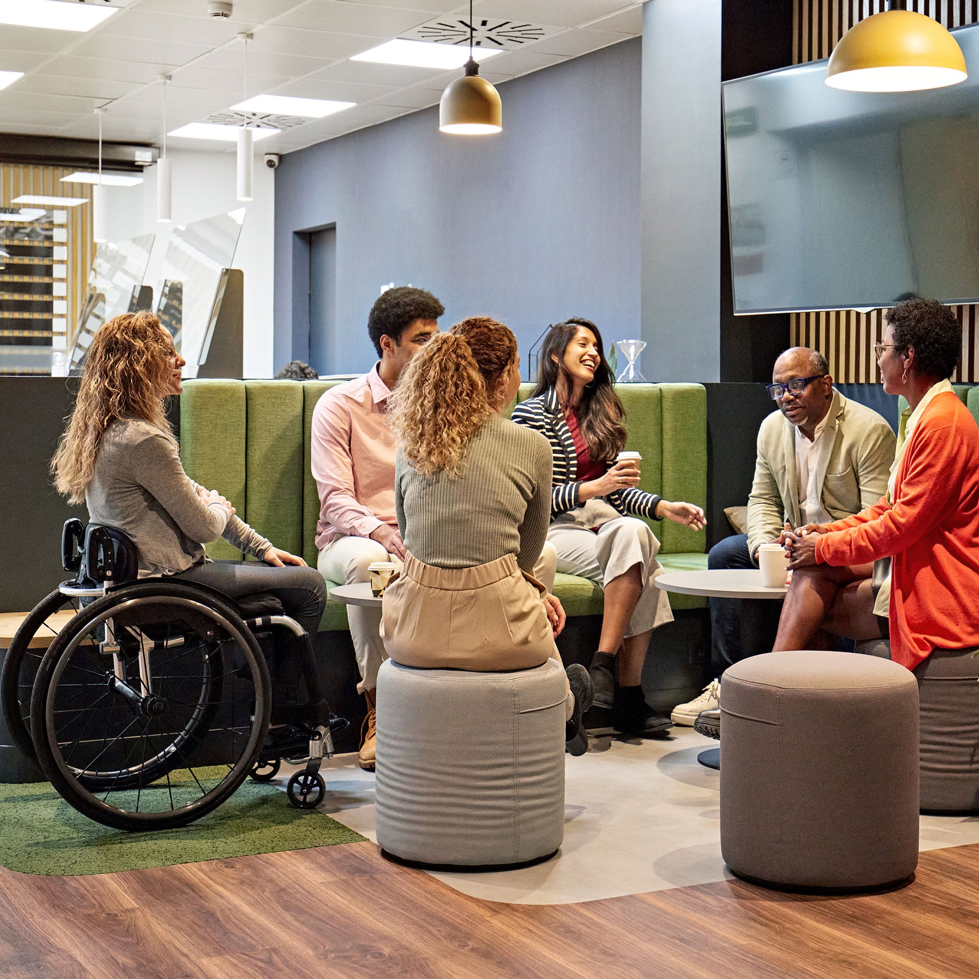 A group of coworkers chatting in an office lounge